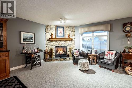 Family Room - walks out to patio area - 509 Highview Point Nw, High River, AB - Indoor Photo Showing Living Room With Fireplace