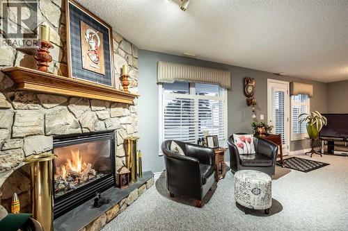 Custom stone facing gas fireplace - 509 Highview Point Nw, High River, AB - Indoor Photo Showing Living Room With Fireplace