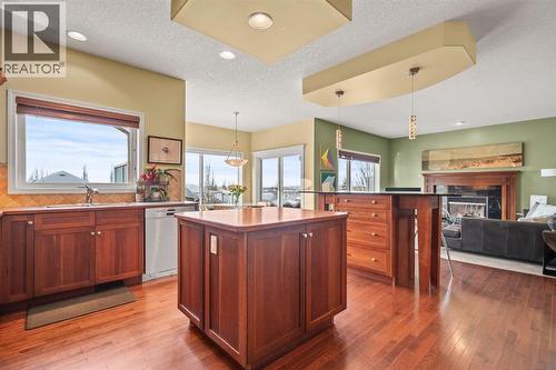 153 Crestridge Way Sw, Calgary, AB - Indoor Photo Showing Kitchen With Fireplace With Double Sink