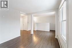 Spare room with baseboard heating and dark wood-style floors - 