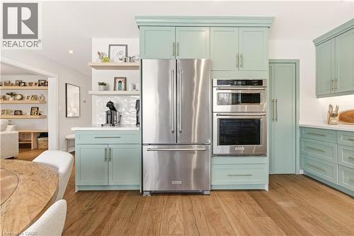Kitchen featuring green cabinets, appliances with stainless steel finishes, and light wood-style flooring - 697 Lambshead Drive, Burlington, ON - Indoor Photo Showing Kitchen