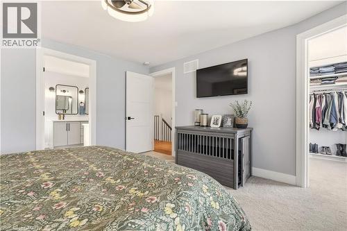 Bedroom with light colored carpet, a spacious closet, and ensuite bathroom - 697 Lambshead Drive, Burlington, ON - Indoor Photo Showing Bedroom