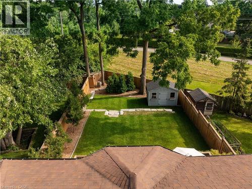 Fenced backyard with an outbuilding, a patio area, and view of scattered trees - 697 Lambshead Drive, Burlington, ON - Outdoor
