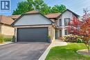 View of front of house featuring a front lawn, asphalt driveway, brick siding, roof with shingles, and an attached garage - 697 Lambshead Drive, Burlington, ON  - Outdoor 