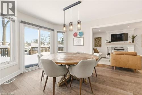 Dining room with light wood finished floors and a brick fireplace - 697 Lambshead Drive, Burlington, ON - Indoor Photo Showing Dining Room With Fireplace