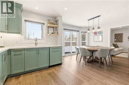 Kitchen with green cabinets, recessed lighting, light wood-style flooring, backsplash, and decorative light fixtures - 697 Lambshead Drive, Burlington, ON - Indoor