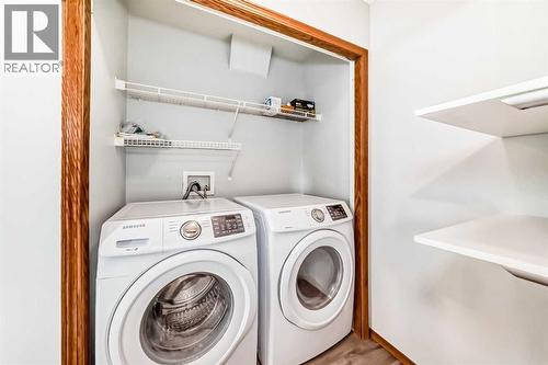 Main level laundry area with shelving.  Washer and dryer are 2 years old - 21 Hillview Road, Strathmore, AB - Indoor Photo Showing Laundry Room
