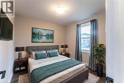 Bedroom featuring dark wood finished floors and baseboards - 