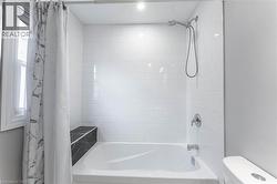 Full bathroom with shower / bath combo with shower curtain and toilet - 