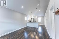 Unfurnished living room featuring lofted ceiling, dark wood-style flooring, and recessed lighting - 