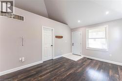 Foyer with vaulted ceiling, dark wood finished floors, and recessed lighting - 