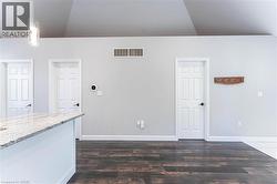 Unfurnished living room featuring dark wood finished floors and baseboards - 