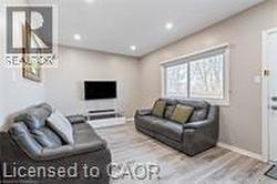 Living room featuring wood finished floors, recessed lighting, and baseboards - 