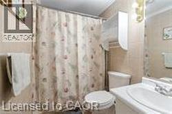 Bathroom featuring vanity, toilet, and a shower with curtain - 