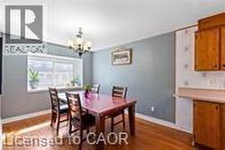 Dining space with dark wood finished floors, a chandelier, and baseboards - 