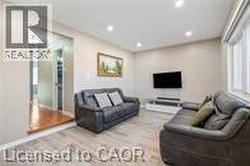 Living area with light wood finished floors, recessed lighting, and baseboards - 