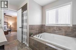 Full bath with a garden tub, a shower with curtain, and marble finish floors - 