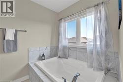 Full bathroom with a garden tub and baseboards - 
