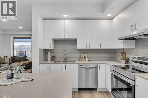 Stainless steel range with ceramic stovetop - photos are of our showhome - 1057 Frost Road Unit# 317, Kelowna, BC - Indoor Photo Showing Kitchen With Stainless Steel Kitchen With Double Sink With Upgraded Kitchen