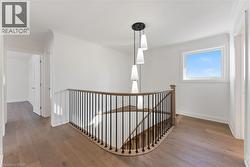 Hallway featuring an upstairs landing, hardwood / wood-style floors, and crown molding - 