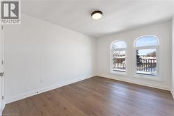Unfurnished room with baseboards and dark wood-style flooring - 