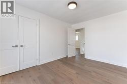 Unfurnished bedroom featuring wood finished floors and a closet - 