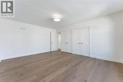 Unfurnished bedroom with multiple closets and hardwood / wood-style flooring - 