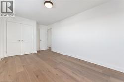 Unfurnished bedroom with hardwood / wood-style floors and a closet - 