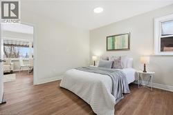 Bedroom featuring multiple windows and wood finished floors - 
