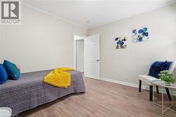 Bedroom with ornamental molding and light wood finished floors - 