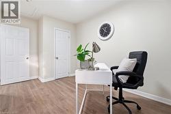 Office area with light wood-style flooring and attic access - 