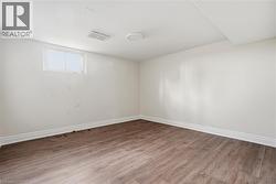 Unfurnished room with baseboards and wood finished floors - 
