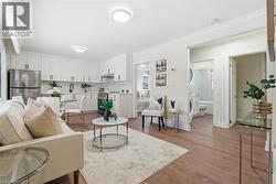 Living room with ornamental molding, light wood finished floors, and stacked washer and clothes dryer - 