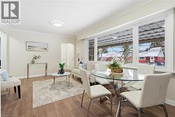 Dining room with crown molding, arched walkways, and wood finished floors - 
