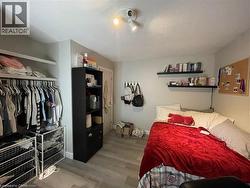 Bedroom featuring wood finished floors, a textured ceiling, and a closet - 