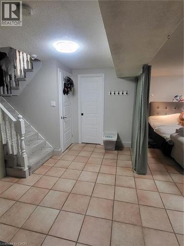 This family room, originally intended as a shared living space, is currently used as a bedroom and home office. It features a fireplace, adding warmth and character to the versatile layout, which comf - 18 Rosewell Street, Hamilton, ON - Indoor Photo Showing Other Room