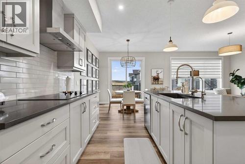 Warm cabinetry and quartz countertops - 307 Precedence Hill, Cochrane, AB - Indoor Photo Showing Kitchen With Upgraded Kitchen