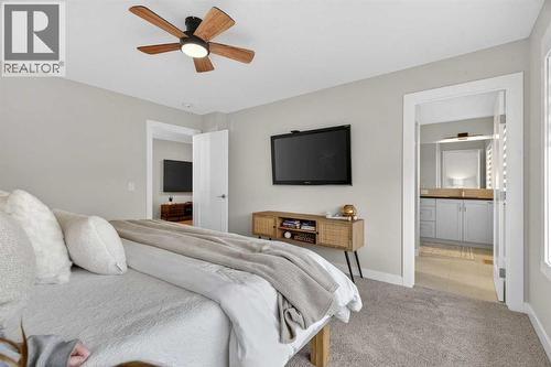 Beautiful and warm primary bedroom that fits a king bed and two large side tables - 307 Precedence Hill, Cochrane, AB - Indoor Photo Showing Bedroom