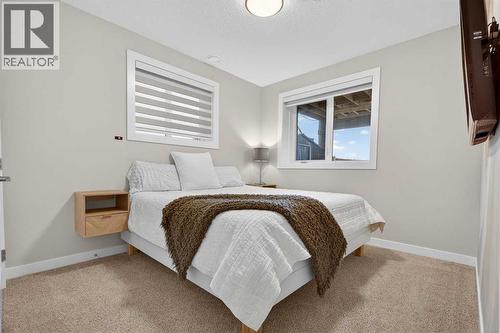 4th bedroom in the basement with two large windows and double door closet - 307 Precedence Hill, Cochrane, AB - Indoor Photo Showing Bedroom