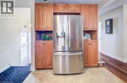 Kitchen featuring stainless steel fridge and wood finish cabinets - 