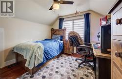 Bedroom with vaulted ceiling, a ceiling fan, and light wood finished floors - 