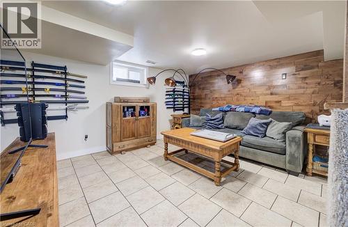 Living room featuring wooden walls, an accent wall, and light tile patterned floors - 1170 Union Street, Kitchener, ON - Indoor