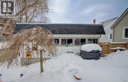 Snow covered back of property with roof with shingles - 