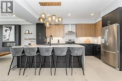 Kitchen with an island with sink, a kitchen bar, stainless steel appliances, modern cabinets, and pendant lighting - 