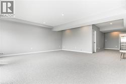 Below grade area with light carpet and recessed lighting - 