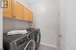 Main level laundry rm w storage cabinets above. - 
