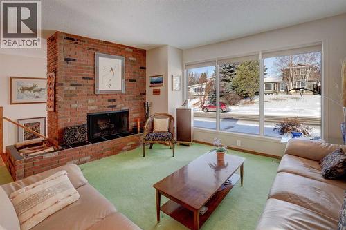 Living Room with a wood burning fireplace - 5943 Silver Ridge Drive Nw, Calgary, AB - Indoor Photo Showing Living Room With Fireplace