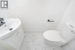 Half bathroom with light marble finish floors and vanity - 