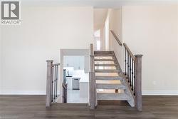 Staircase featuring baseboards and wood finished floors - 