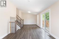 Unfurnished room with wood finished floors and stairway - 